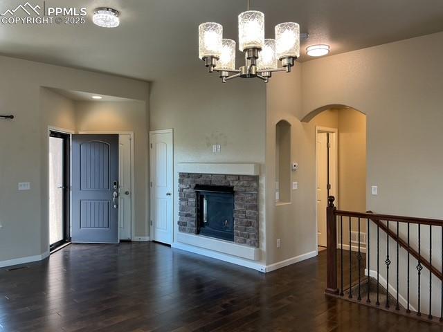 Image 7 of 37: Unfurnished living room with dark wood-style floors, a fireplace, a chandel