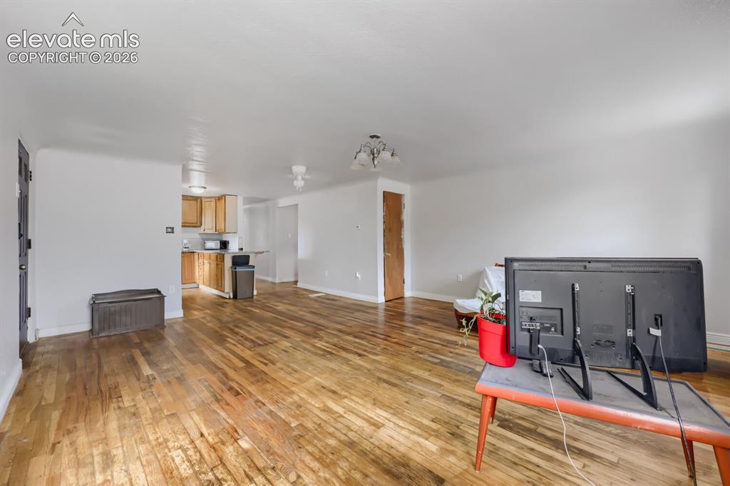 Image 14 of 36: Wood-finish flooring throughout, light neutral wall paint, and overhead lig
