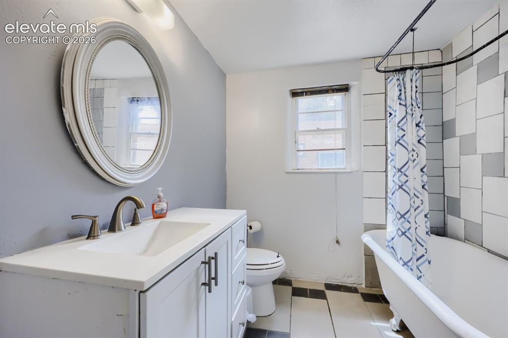 Image 23 of 36: White vanity with an integrated sink and brushed nickel fixtures