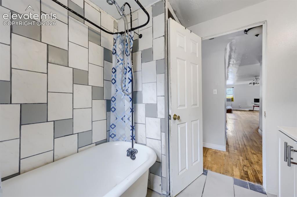 Image 24 of 36: White freestanding bathtub with a shower attachment