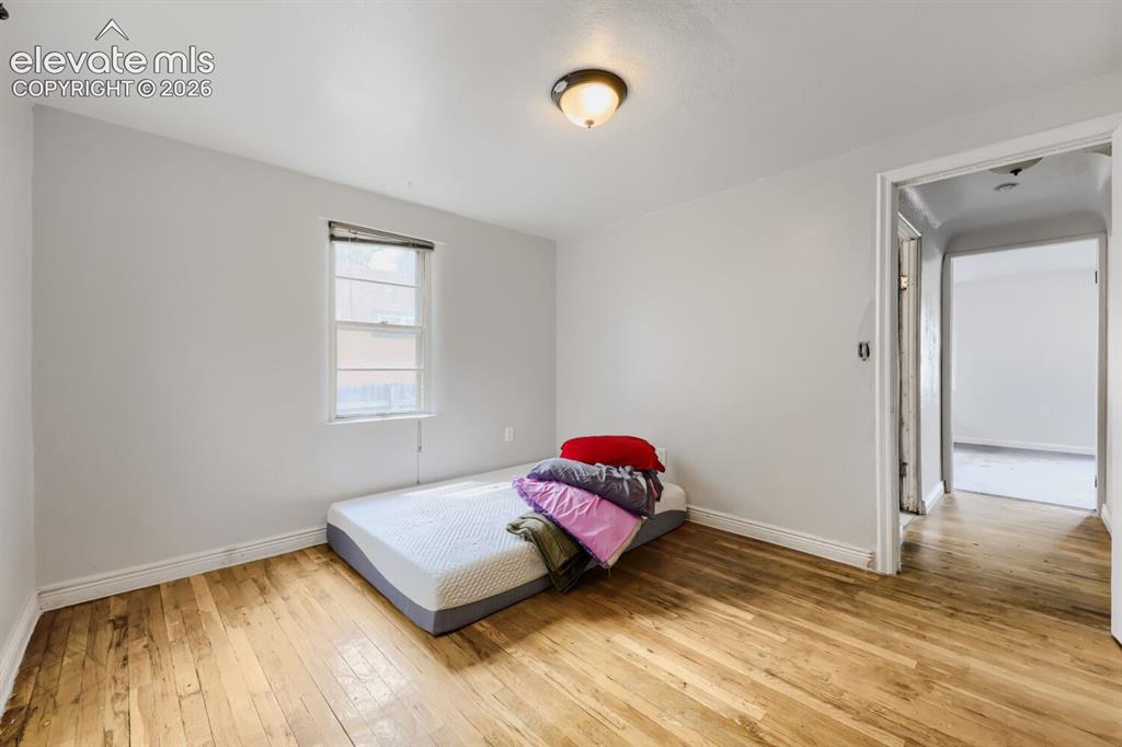 Image 29 of 36: Hardwood flooring, painted walls, single window with blinds, overhead light
