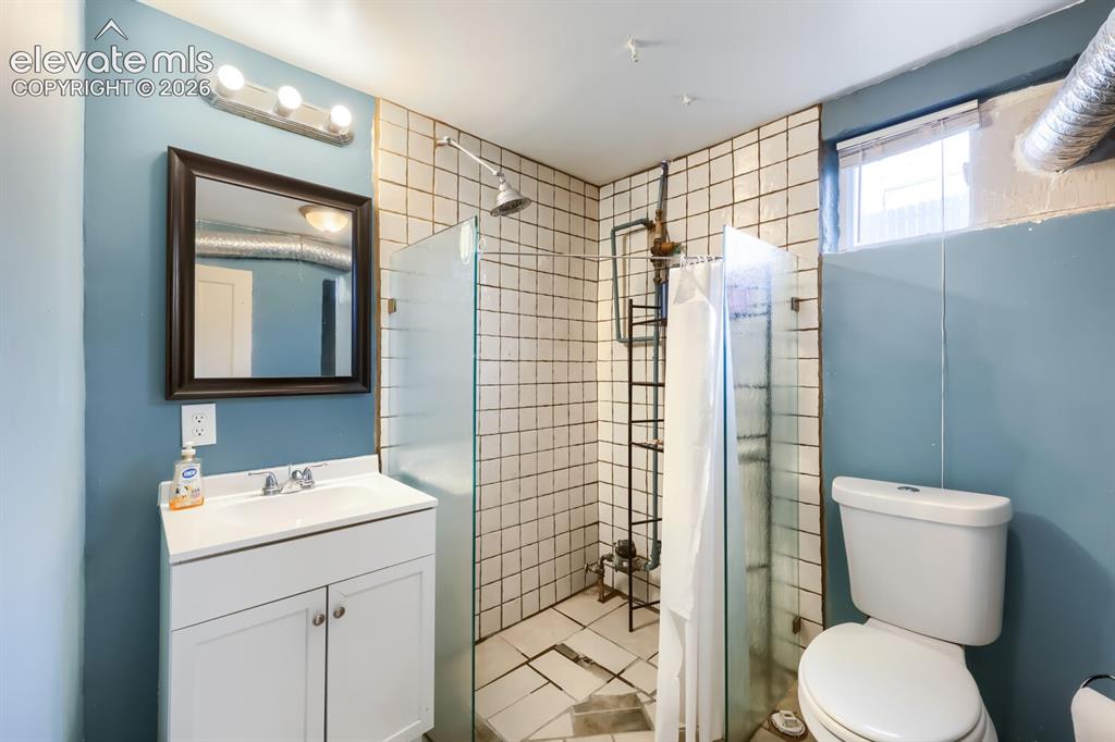 Image 30 of 36: Vanity with integrated sink, framed mirror, and chrome fixtures