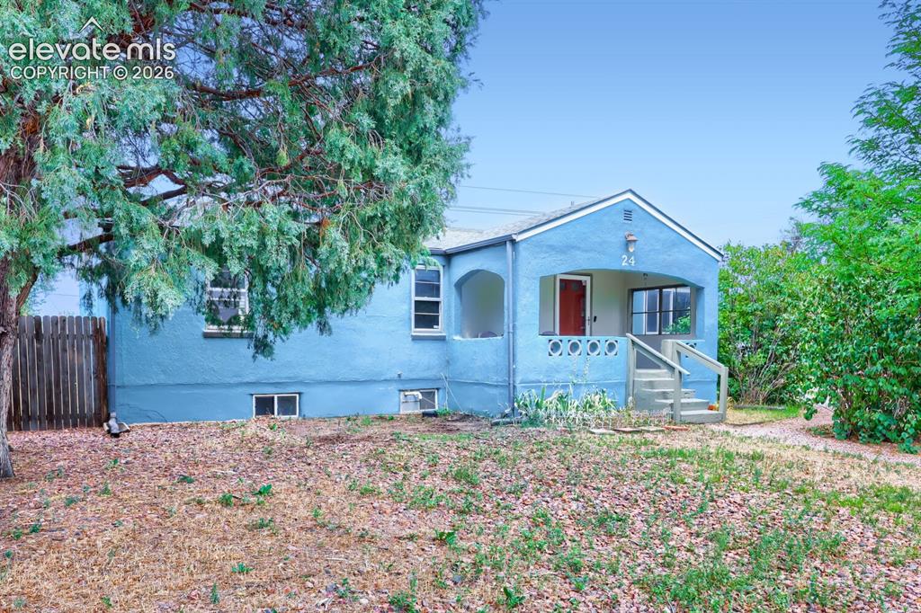 Image 36 of 36: Light blue exterior with a covered porch featuring decorative concrete balu