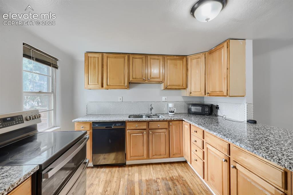 Image 8 of 36: Kitchen featuring wood-finish cabinetry, granite countertops, stainless ste