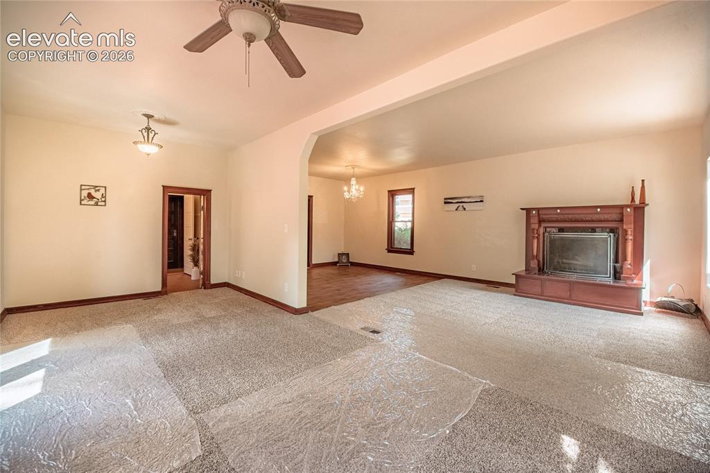 Image 12 of 47: Spacious living area featuring a decorative fireplace, carpeted flooring, a
