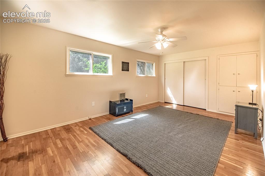 Image 18 of 47: Wood-finish flooring throughout, complemented by a ceiling fan with integra