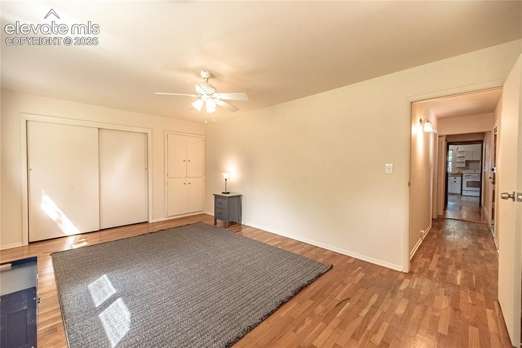 Image 20 of 47: Wood-finish flooring with built-in cabinetry, sliding closet doors, a ceili