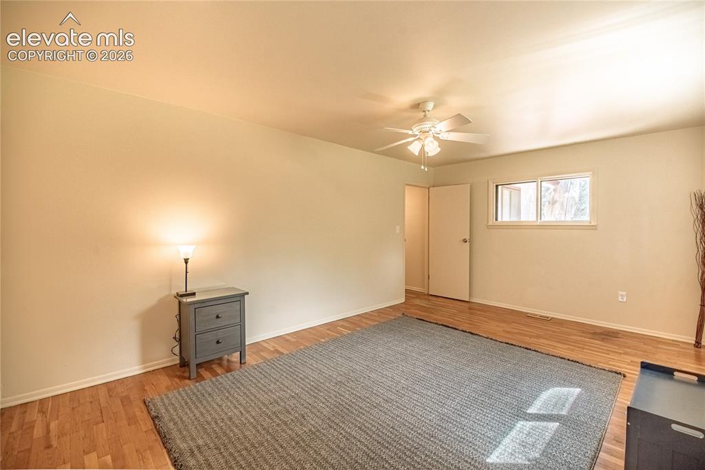 Image 21 of 47: Wood-finish flooring with a ceiling fan light fixture and a double window