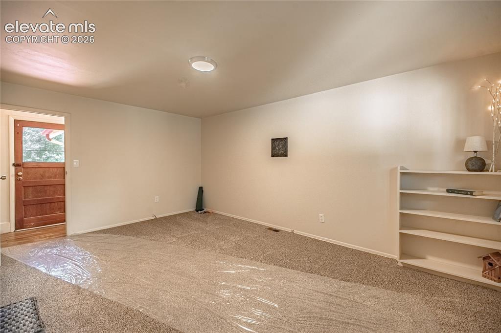 Image 24 of 47: Carpeted flooring, recessed ceiling lighting, light-toned wall paint, built