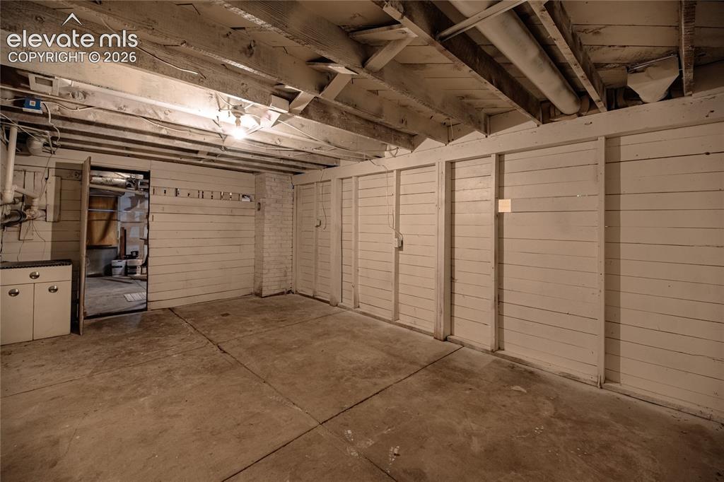 Image 28 of 47: Exposed ceiling joists, concrete flooring, and built-in storage units