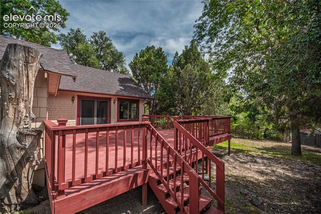 Image 34 of 47: Expansive outdoor deck with red-painted railings and steps, featuring multi