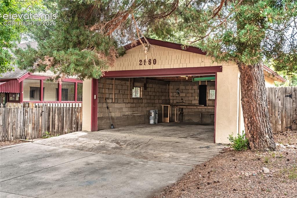 Image 36 of 47: Detached garage with a wide concrete driveway, concrete block interior wall