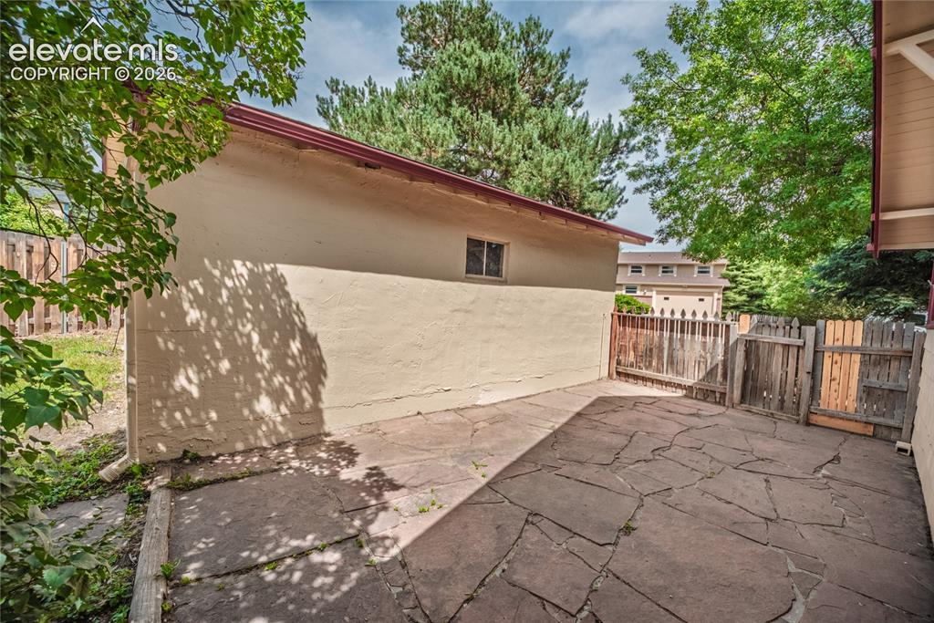 Image 43 of 47: Flagstone patio with a wood privacy fence