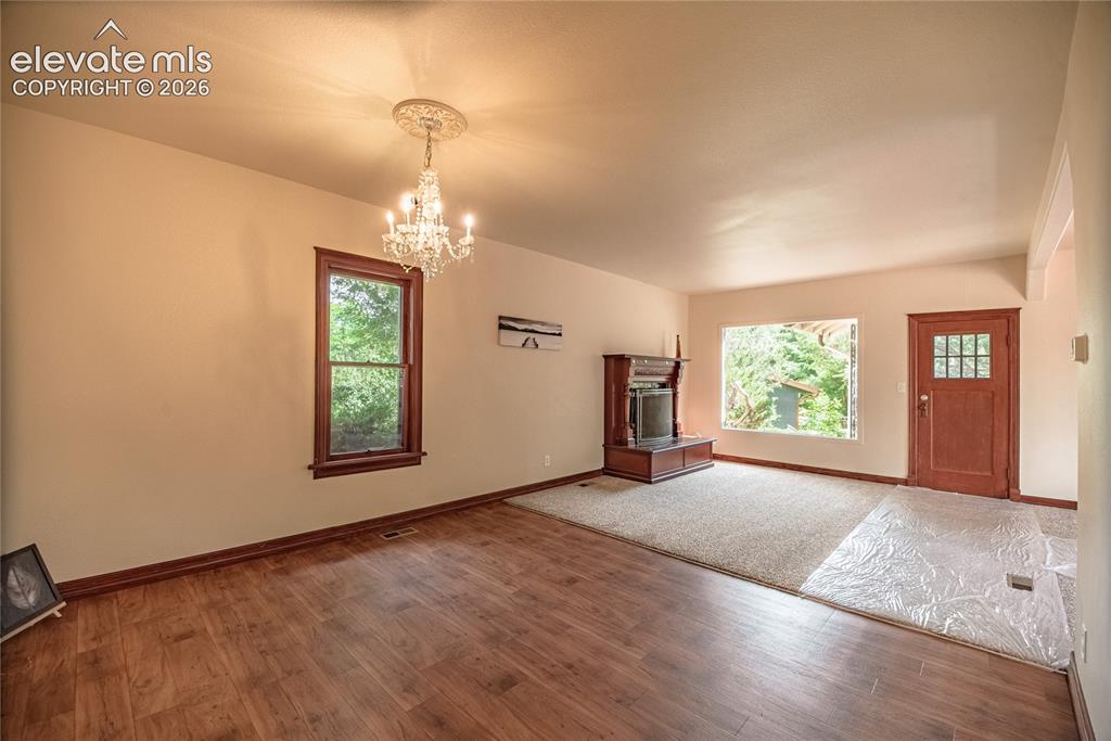 Image 7 of 47: Wood-finish flooring with a complementary carpeted area, multiple windows w