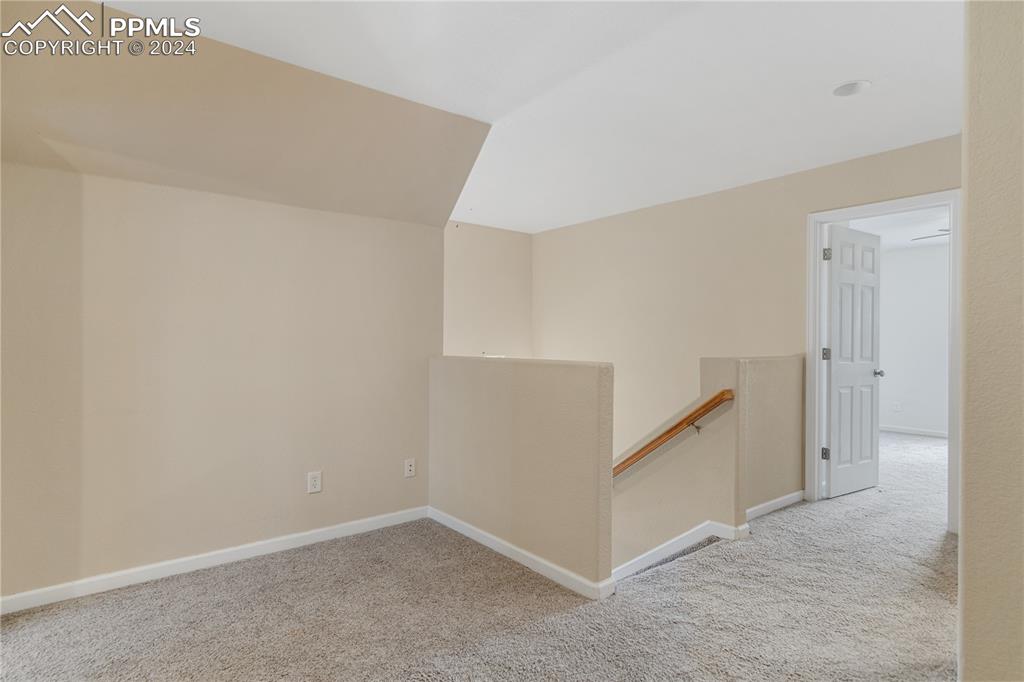 Image 15 of 30: Hall featuring light colored carpet and lofted ceiling