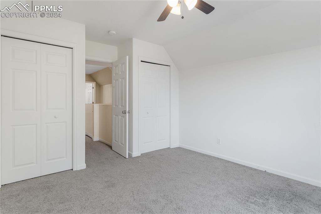Image 16 of 30: Unfurnished bedroom featuring ceiling fan, vaulted ceiling, and carpet floo