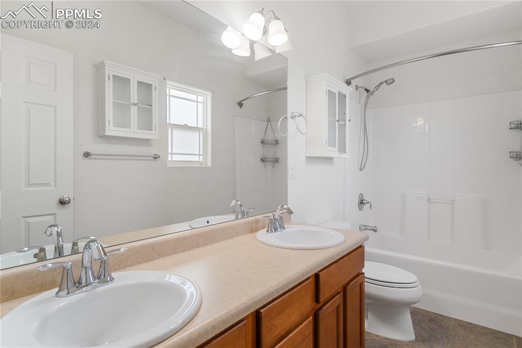 Image 18 of 30: Full bathroom featuring toilet, tile flooring, dual vanity, and bathing tub
