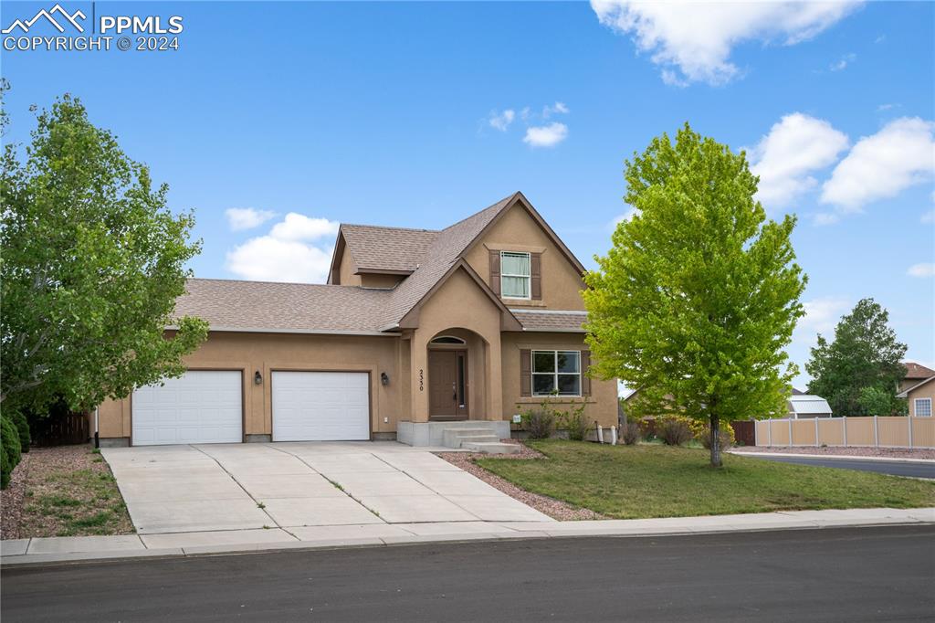 Image 2 of 30: View of front of property with a front lawn and a garage