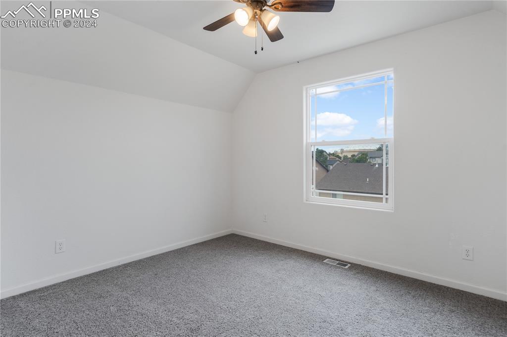Image 20 of 30: Bonus room with ceiling fan, carpet floors, and lofted ceiling