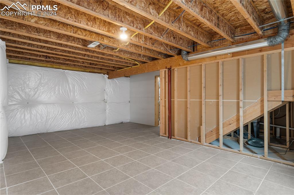 Image 23 of 30: Basement featuring tile flooring
