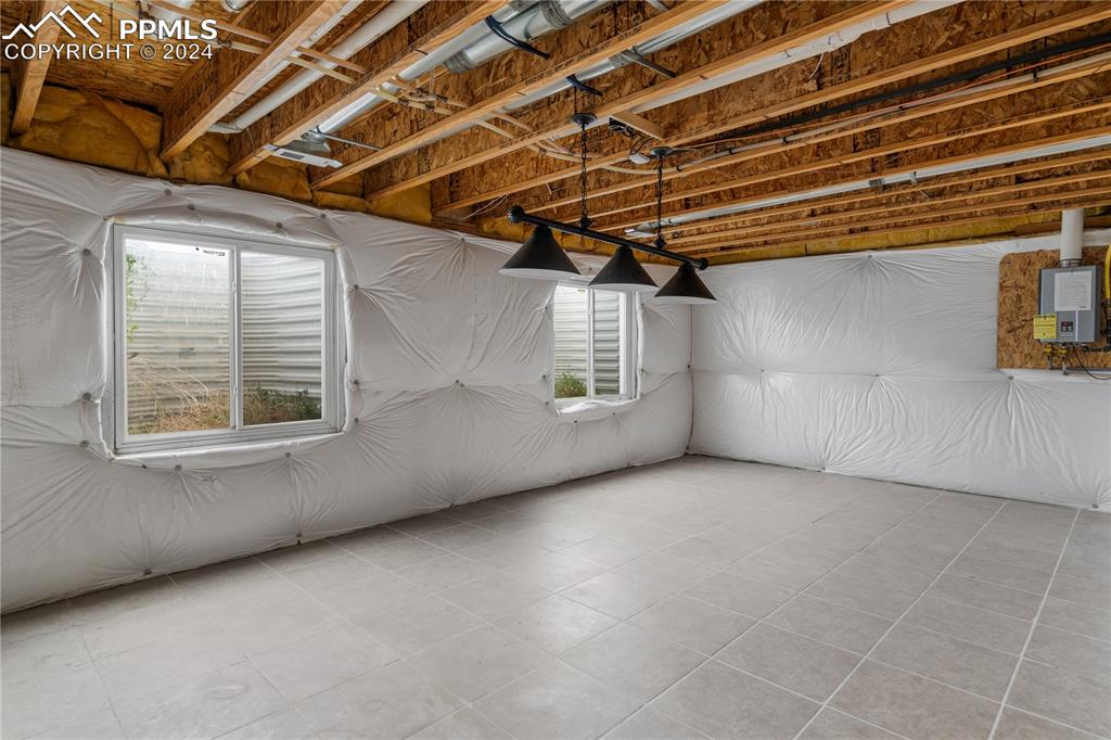 Image 25 of 30: Basement featuring plenty of natural light and light tile floors