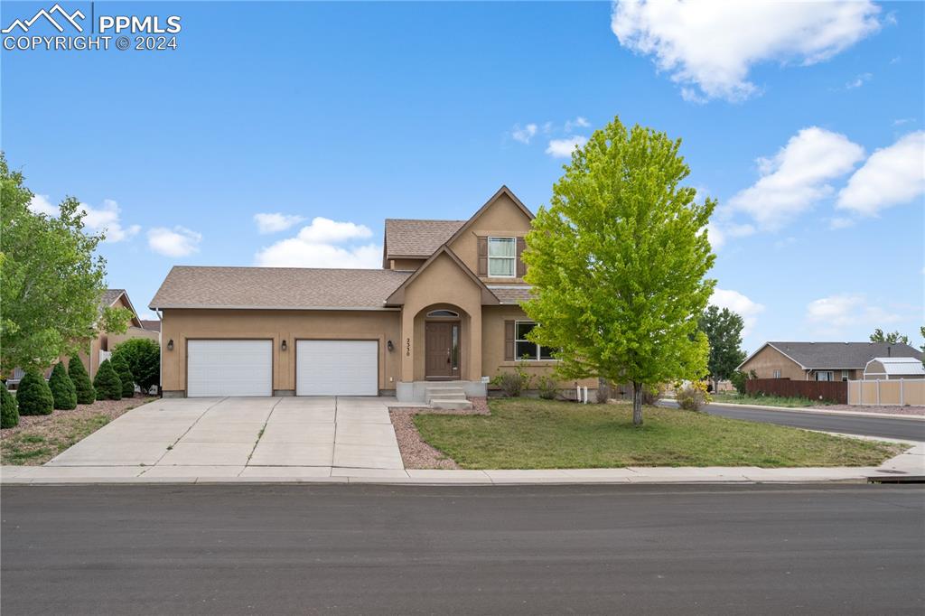Image 3 of 30: View of front of property with a front yard and a garage
