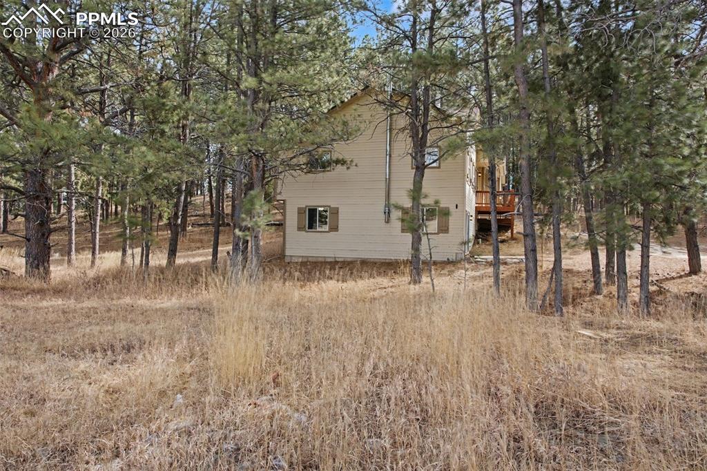 Image 34 of 49: View of property exterior featuring a deck and view of scattered trees
