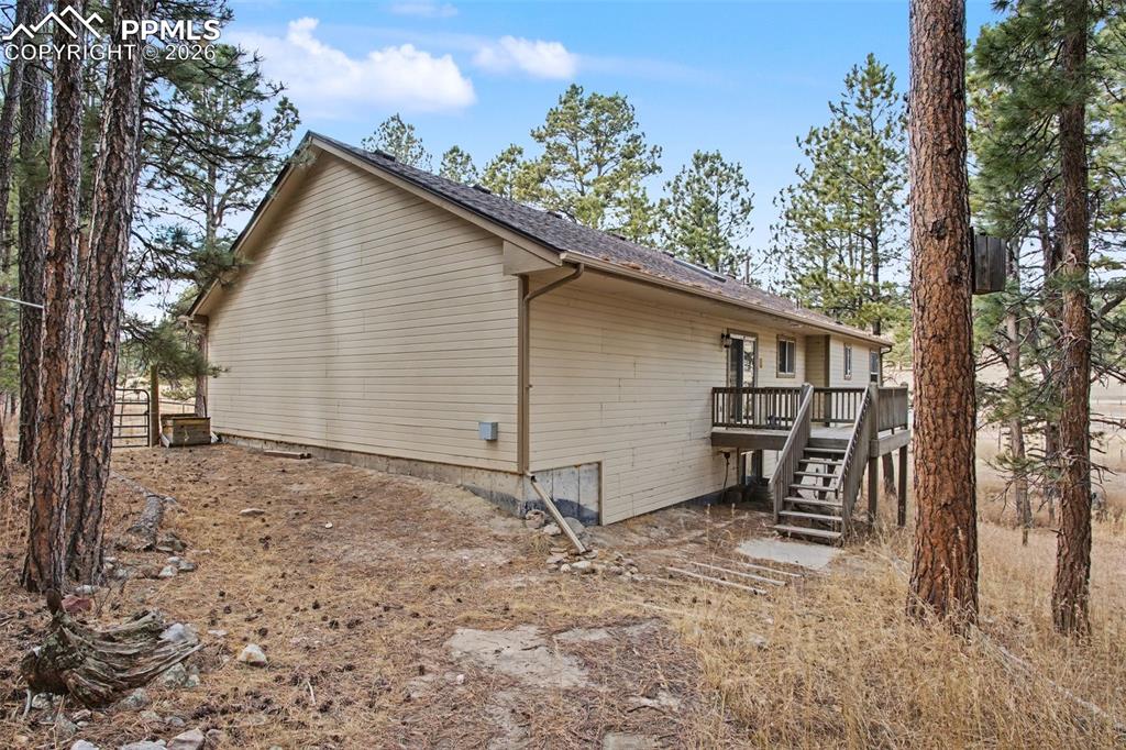 Image 36 of 49: View of side of property featuring stairway and a deck