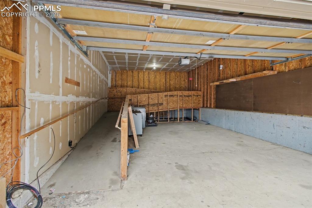 Image 40 of 49: Misc room featuring a garage and concrete flooring