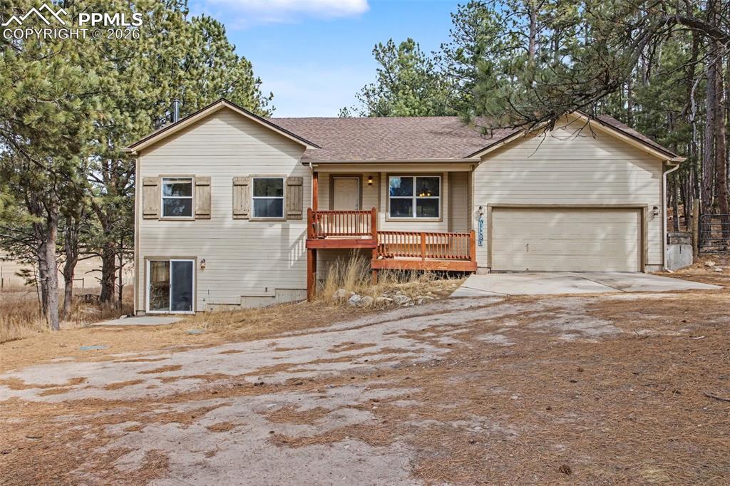 Image 46 of 49: Ranch-style house featuring driveway, a porch, a shingled roof, and an atta