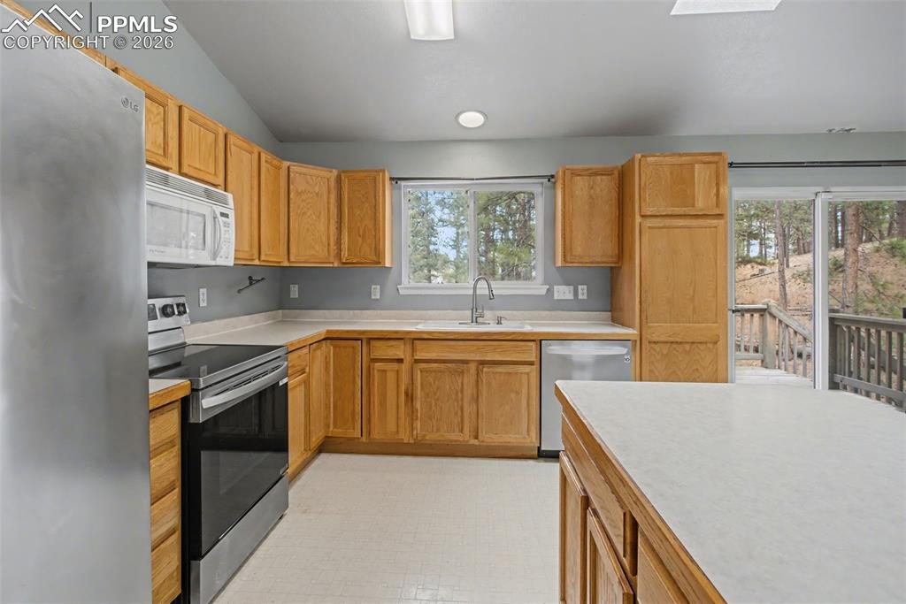 Image 8 of 49: Kitchen with stainless steel appliances, light countertops, light flooring,
