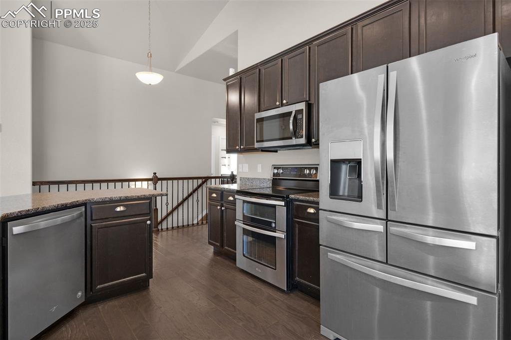 Image 11 of 38: Kitchen with appliances with stainless steel finishes, decorative light fix
