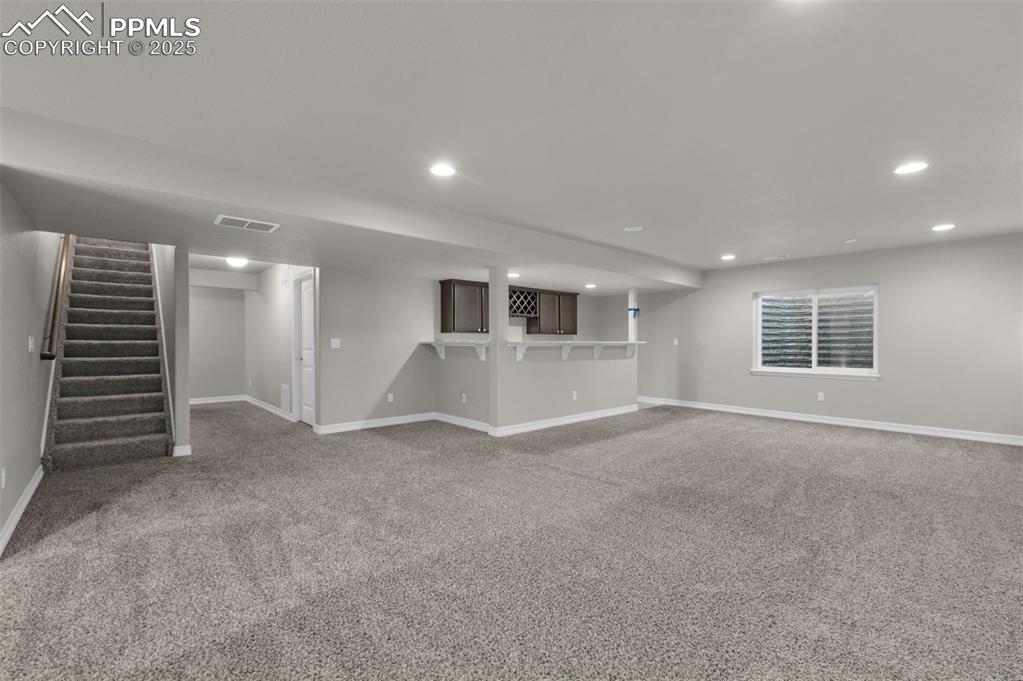 Image 25 of 38: Huge basement family room with wet bar