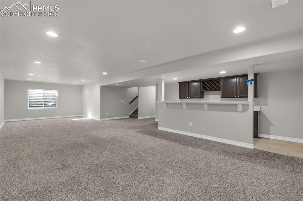 Image 26 of 38: Unfurnished living room with light colored carpet, recessed lighting, and s
