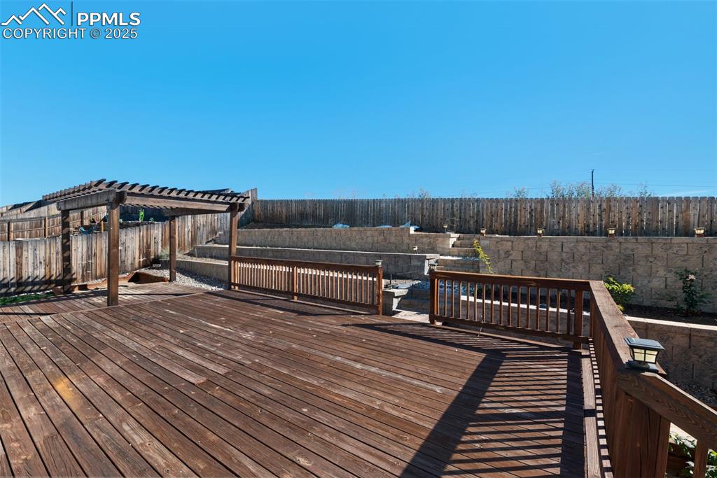 Image 35 of 38: Wooden deck featuring a fenced backyard and a pergola