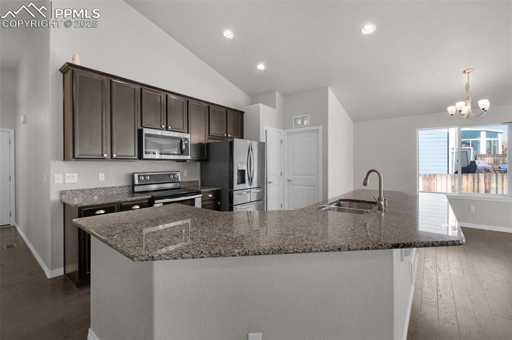 Image 9 of 38: Kitchen with dark brown cabinetry, appliances with stainless steel finishes