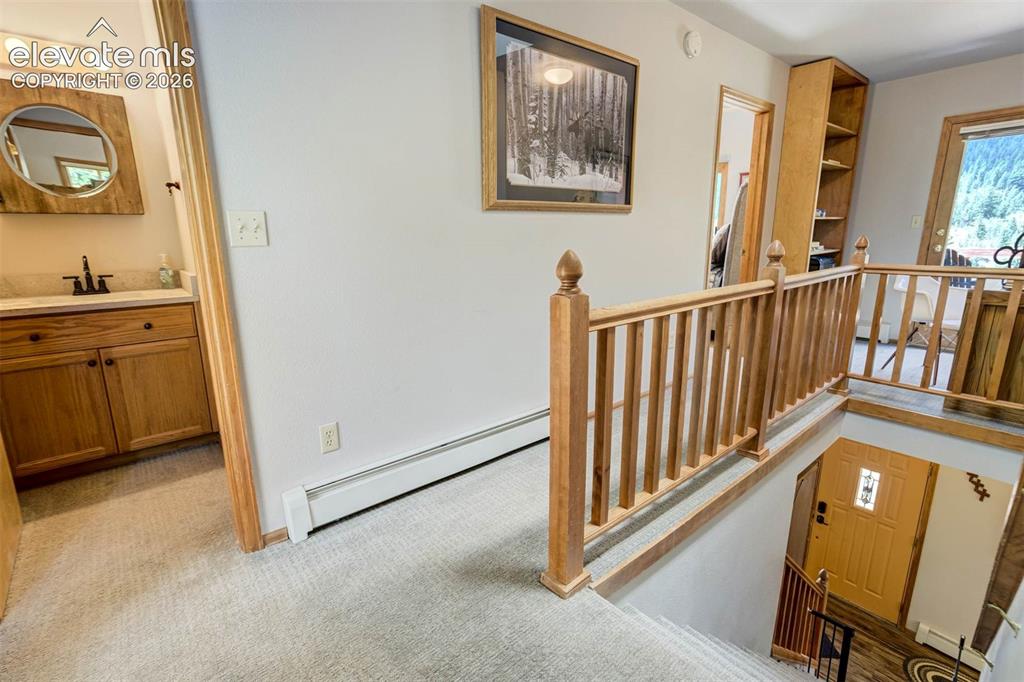 Image 21 of 43: Upstairs-Vanity for 2nd BR/Bunkroom and stairs to front door.