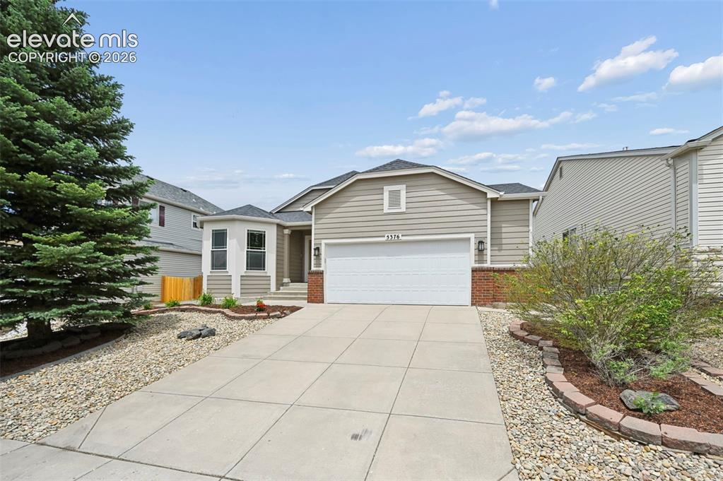 Image 1 of 33: Single-story residence featuring light gray siding with brick accents, a tw