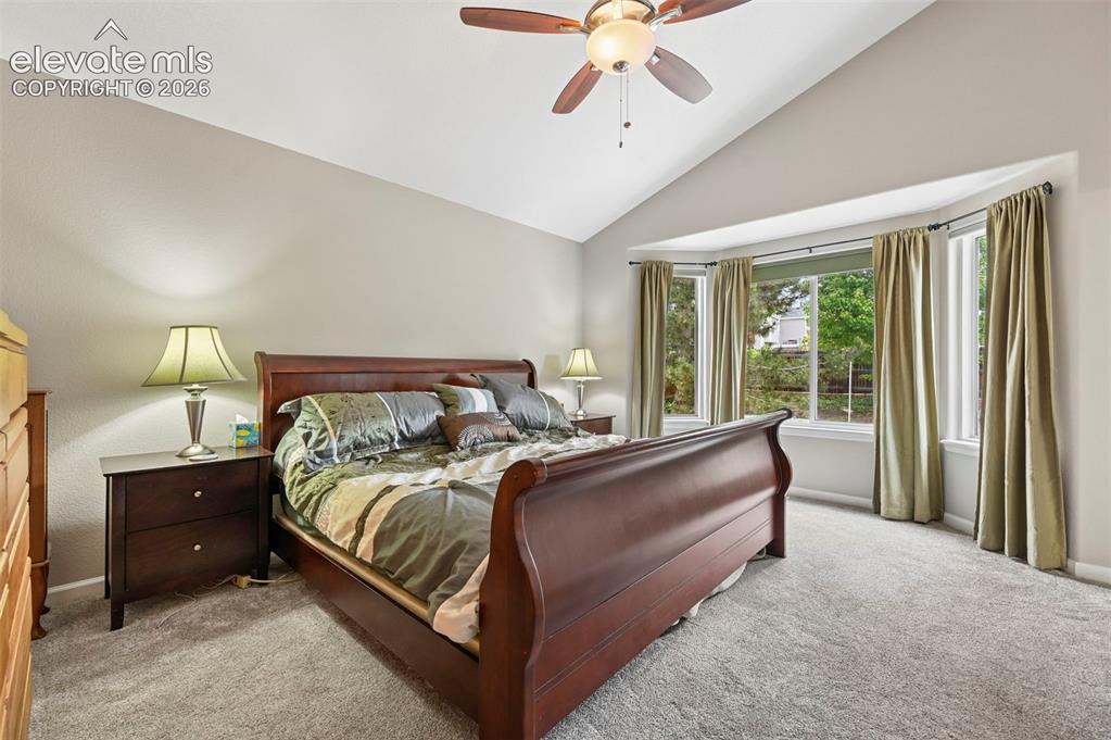 Image 12 of 32: Spacious room featuring vaulted ceilings, a prominent bay window, and soft