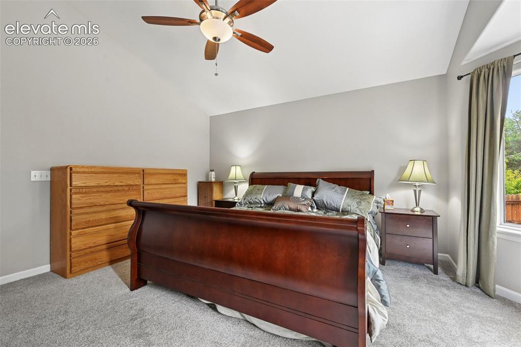 Image 13 of 32: Vaulted ceiling bedroom featuring light gray wall paint, gray carpet floori