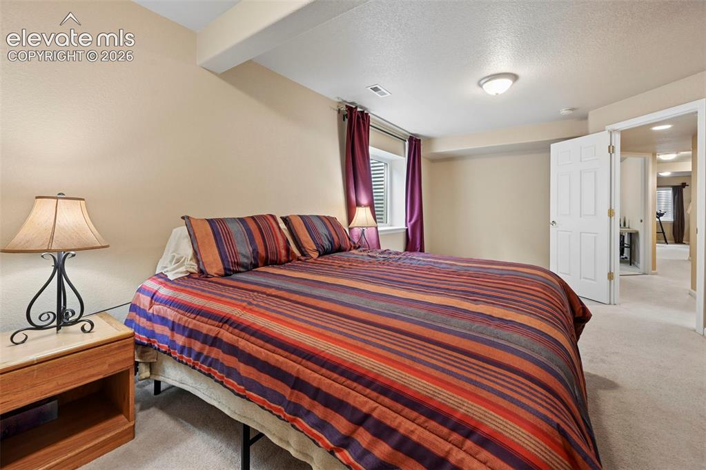 Image 14 of 32: Bedroom featuring light beige walls and light-colored carpeting