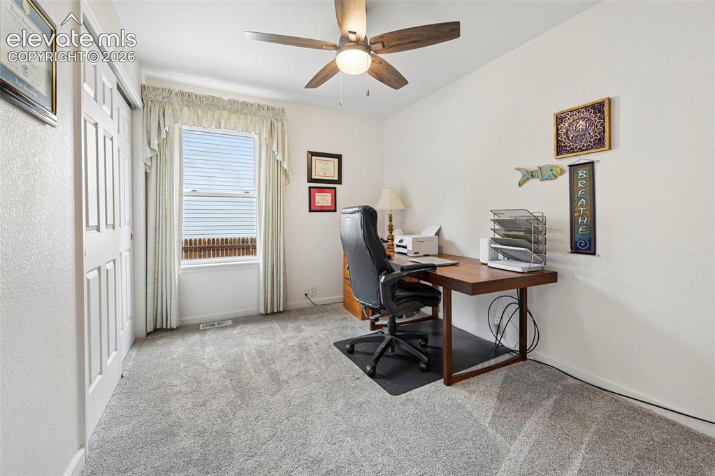 Image 18 of 32: Carpeted room featuring a ceiling fan, a window with blinds, and bi-fold cl