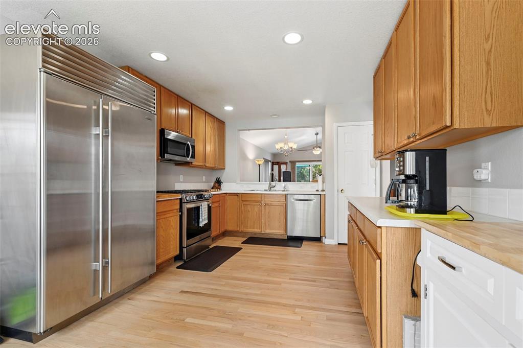 Image 2 of 32: Kitchen featuring wood-finish flooring, recessed lighting, wood cabinetry,