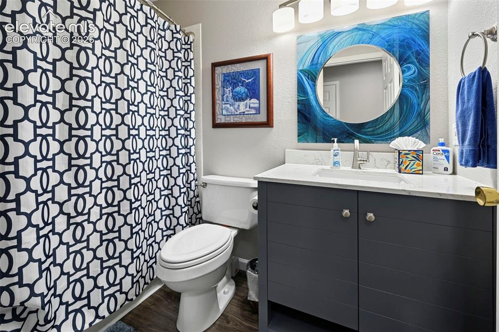 Image 22 of 32: Bathroom featuring a single vanity with a white countertop, dark wood-finis