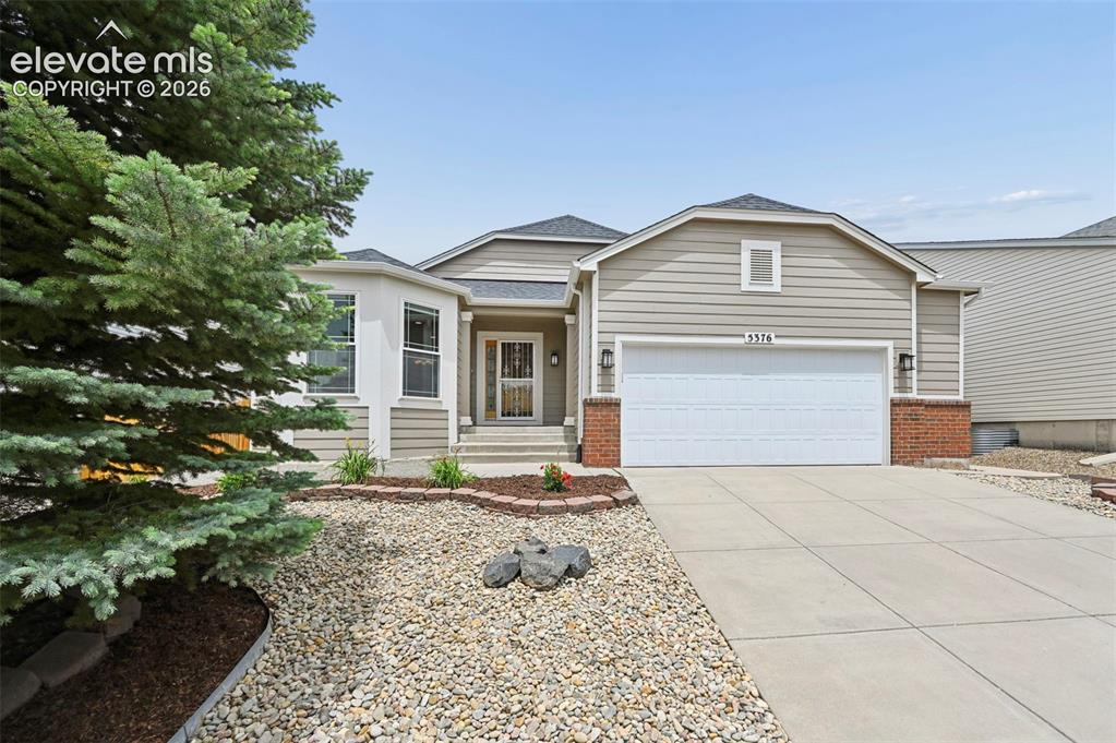 Image 30 of 33: Single-story residence featuring light-toned siding, a two-car garage, and