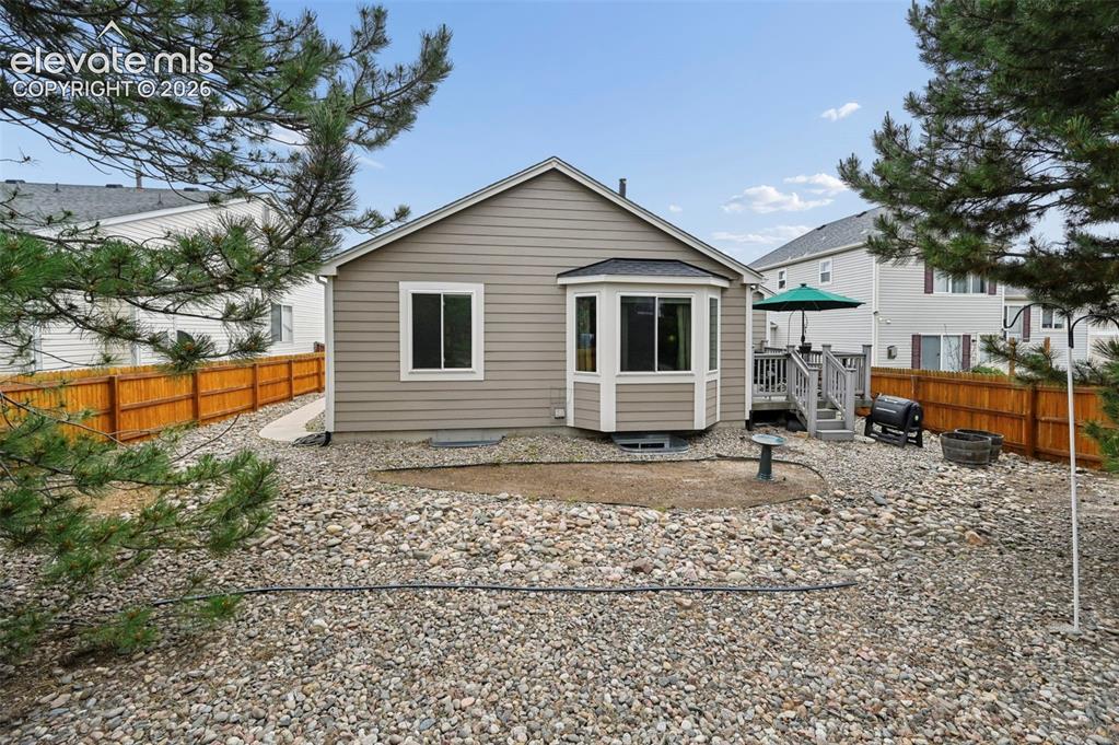 Image 31 of 33: Rear exterior featuring neutral-toned siding, a multi-pane bay window, and