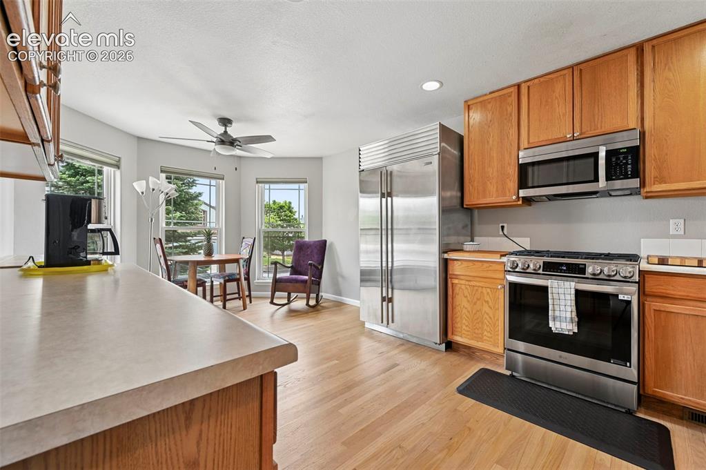 Image 5 of 32: Kitchen featuring natural wood cabinetry, stainless steel appliances, and w