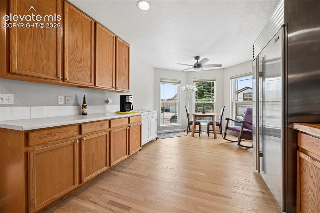 Image 6 of 32: Kitchen featuring extensive wood cabinetry, white countertops, stainless st