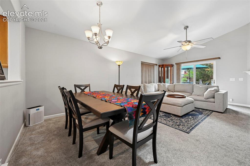 Image 8 of 33: Open-concept room featuring vaulted ceilings, a dining area with a chandeli