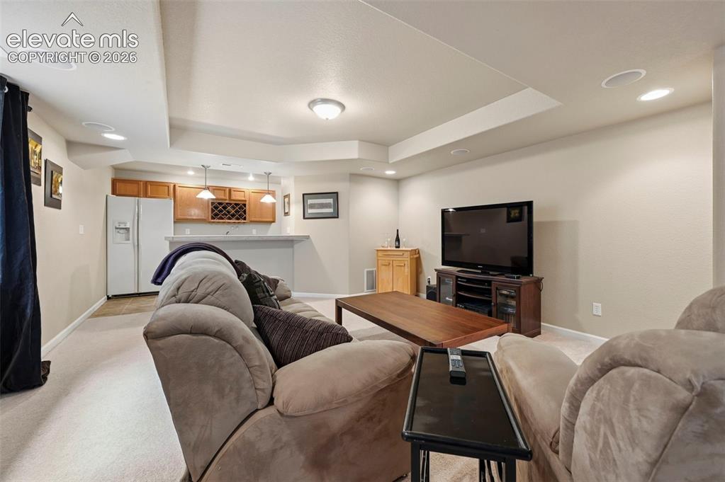 Image 9 of 32: Spacious entertainment area featuring recessed lighting, a built-in bar wit